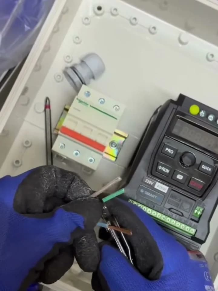 Técnico de SMARTIND cableando un variador de la marca dentro de un tablero de control