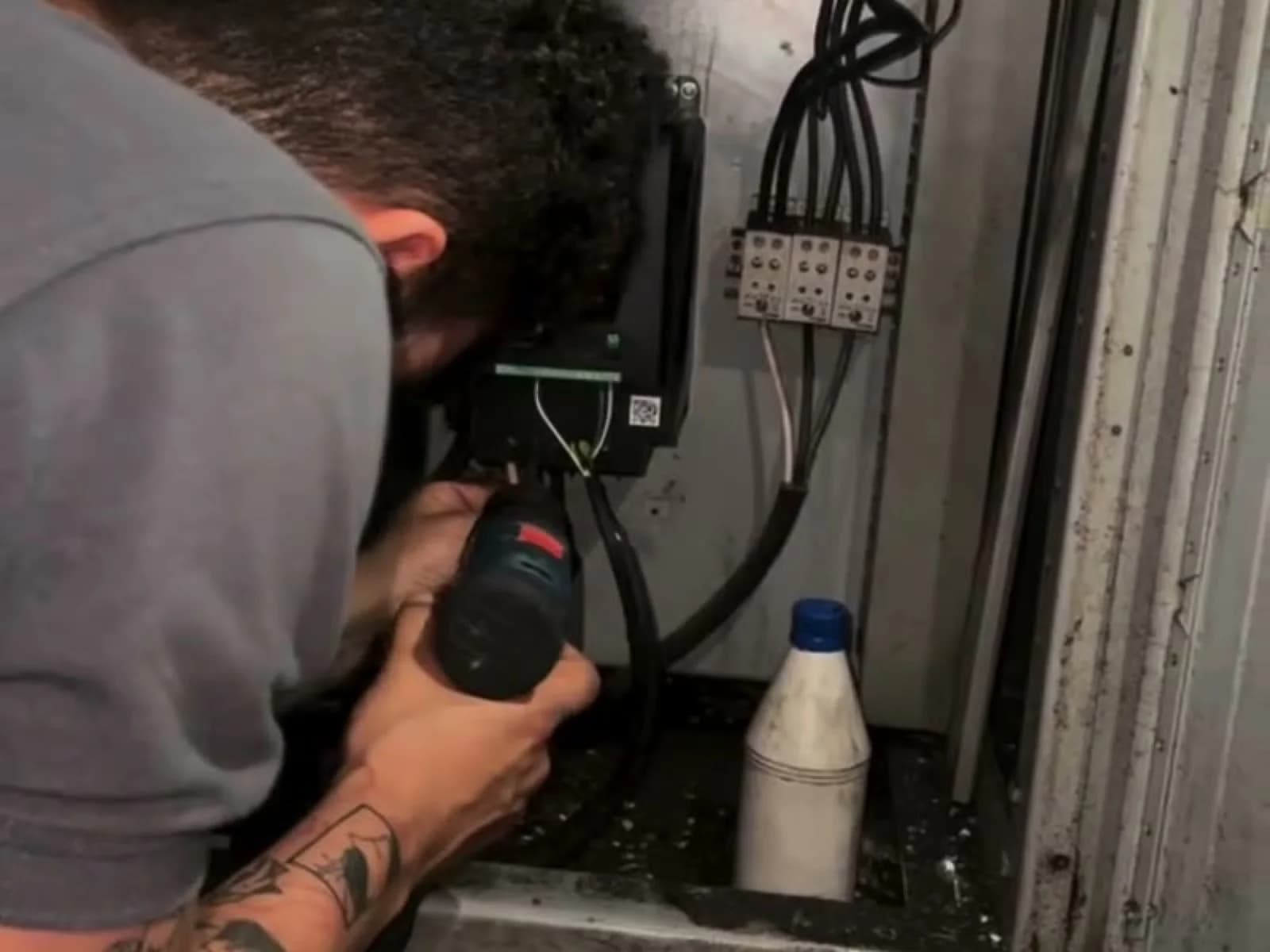 Técnico de SMARTIND midiendo dentro del tablero de una sopladora de plásticos
